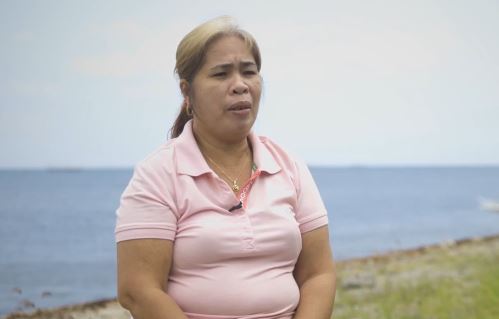 Josie Dequina spricht in einem rosa Poloshirt in die Kamera