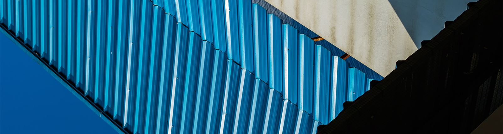Abstraktes Bild mit blauen Wellblechpaneelen.