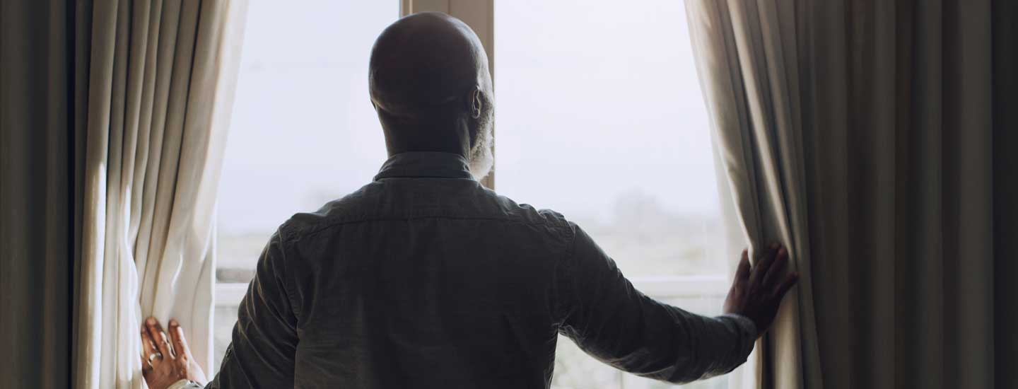 A man gazes thoughtfully out of a window