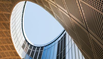 View from inside a building, looking up at a clear blue sky framed by the structure's edges