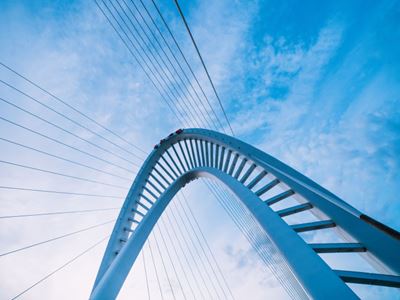 Curved bridge against a blue sky