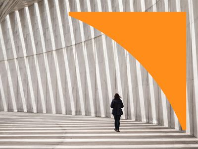 Person walking in a curved concrete corridor with vertical pillars