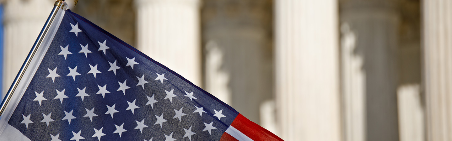 An American flag with columns in the background