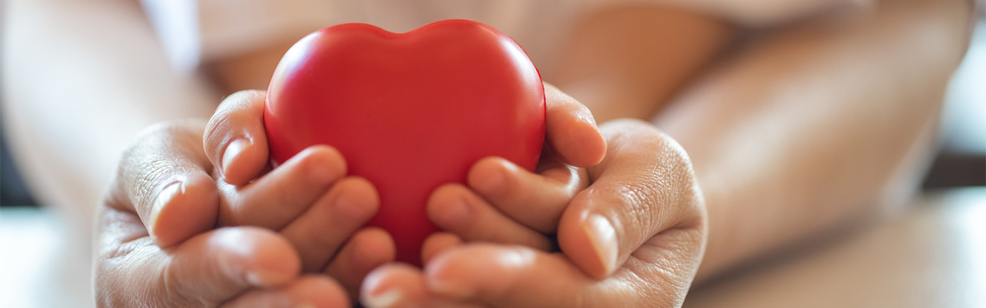 A parent and child hold a heart-shaped figurine.