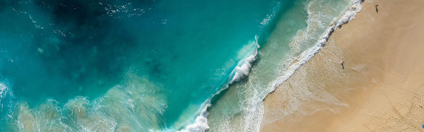 Red canoes on turquoise lake with evergreen forest.