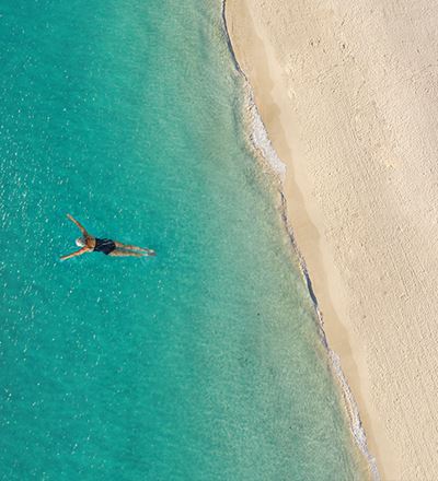 Snorkeler in tropical waters from above
