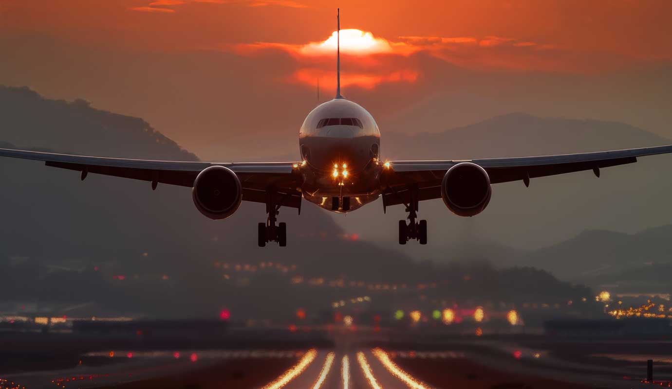 A plane landing at sunset