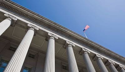 Building with tall columns and an American flag on top.Building with tall columns and an American flag on top.