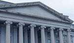 Front view of classical building with tall columns and triangular pediment.