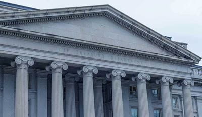 Front view of classical building with tall columns and triangular pediment.