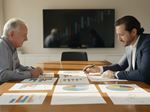 Advisor and client discussing financial data and charts.