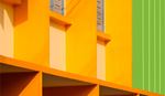 Detailed view of a building showcasing a striking green and yellow color palette, emphasizing its unique design elements.