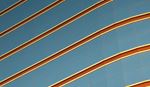 Abstract architectural pattern with diagonal metallic lines across a blue glass