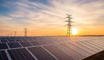 Solar panels and power lines at sunset.