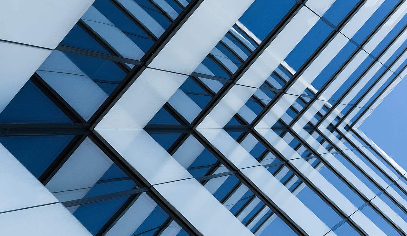 Sleek office building set against a bright blue sky, highlighting its modern architectural features.