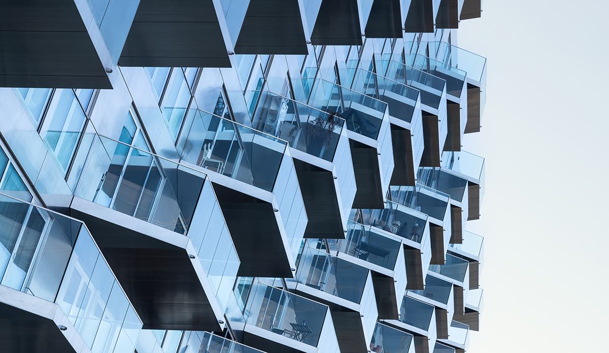 A multi-story building featuring numerous windows and balconies on its facade.