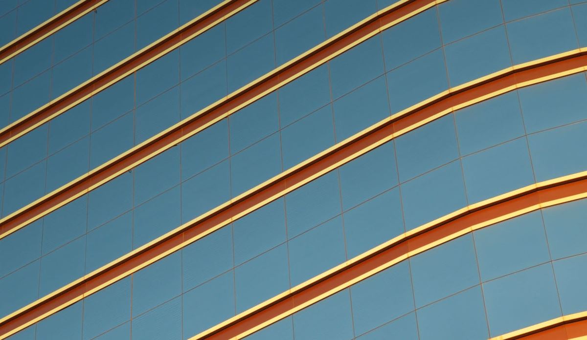 Abstract architectural pattern with diagonal metallic lines across a blue glass