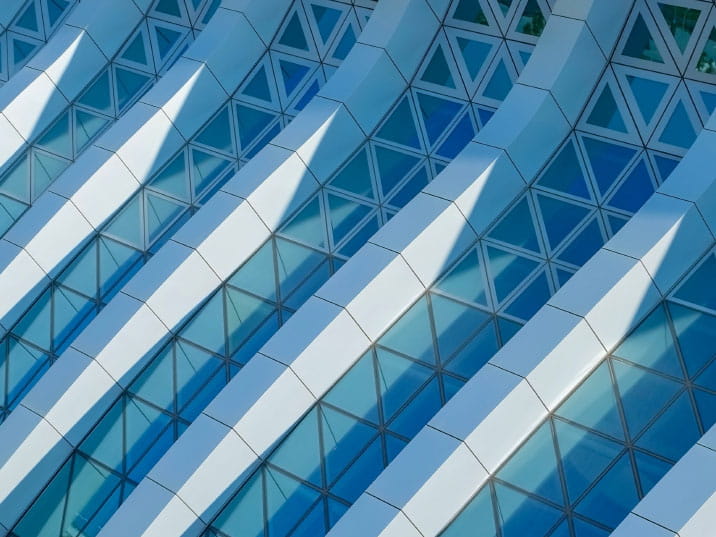 Modern building featuring blue glass structure with triangular framework