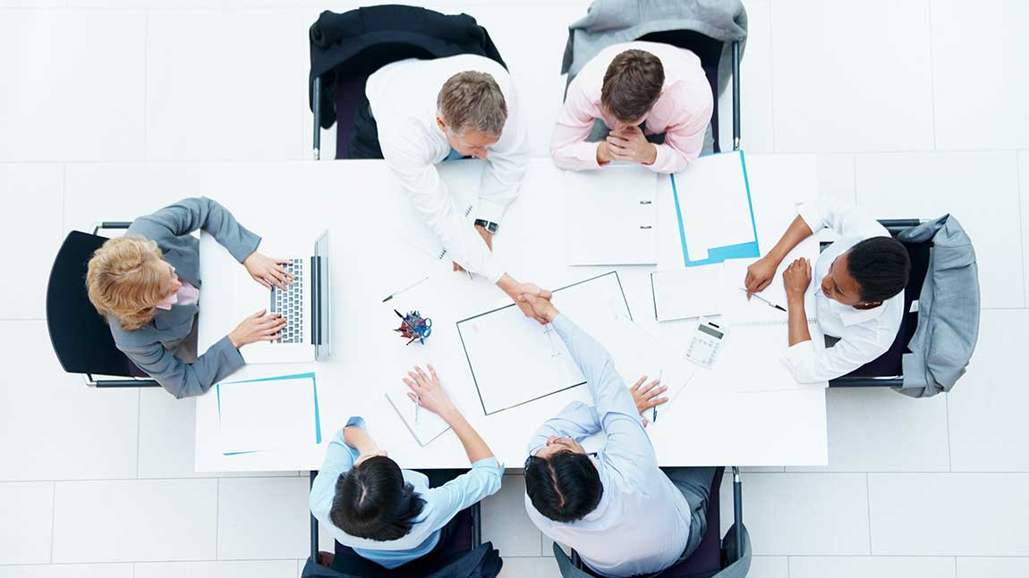 Birdseye view of people in a meeting around a meeting table