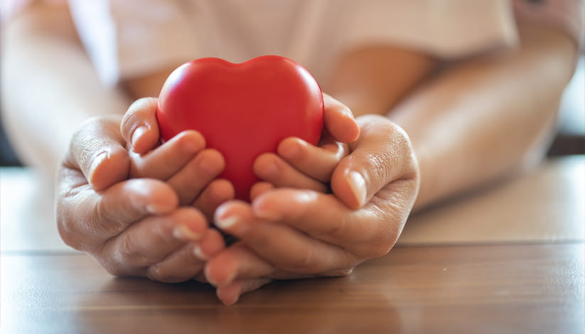 A parent and child hold a heart-shaped figurine.
