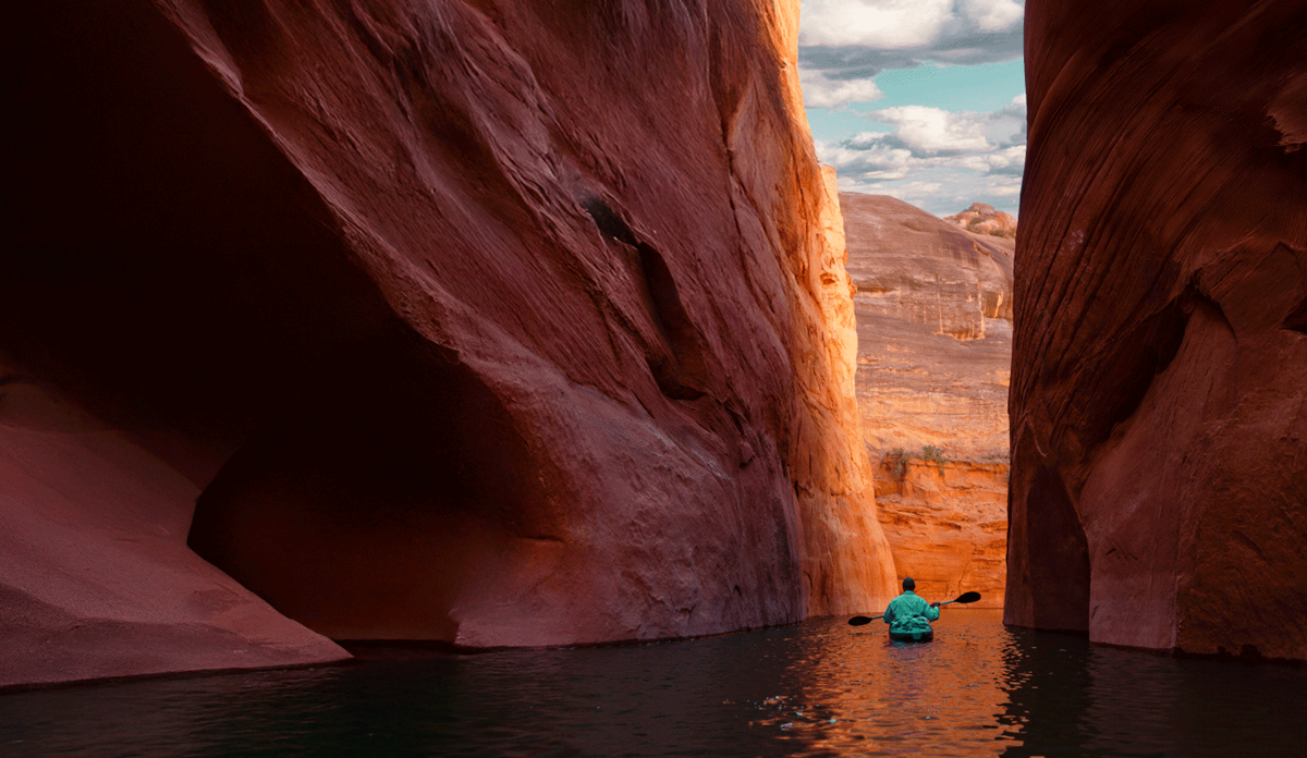 A small boat floating through a narrow canyon