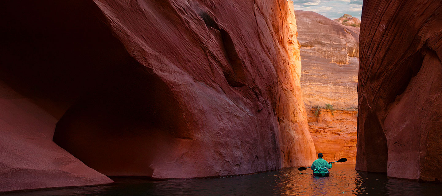 A small boat floating through a narrow canyon