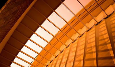 An architectural view of a building with a significant large window, emphasizing its design and connection to the environment.