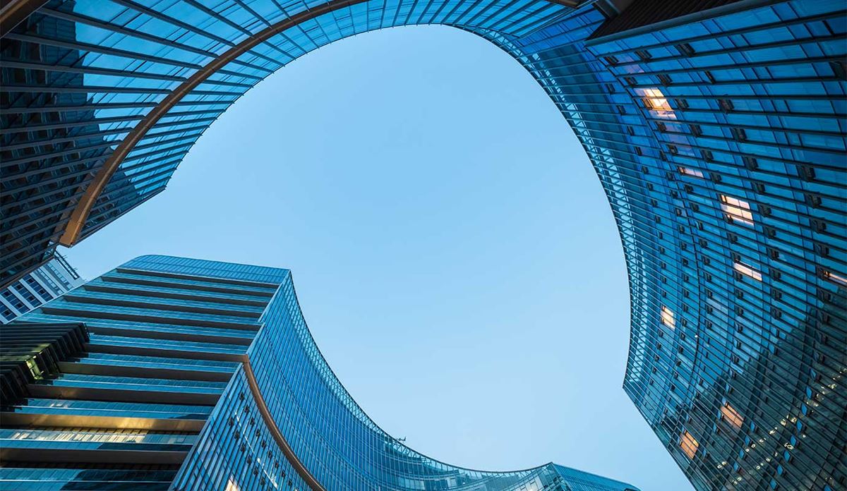 View looking up at modern glass skyscrapers