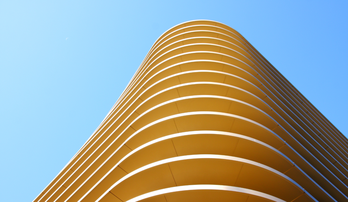 Modern curved yellow skyscraper viewed from below