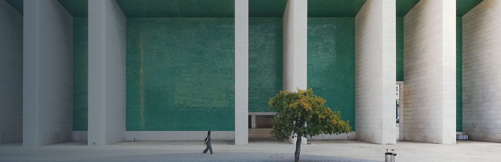 A person walking in front of a large building.