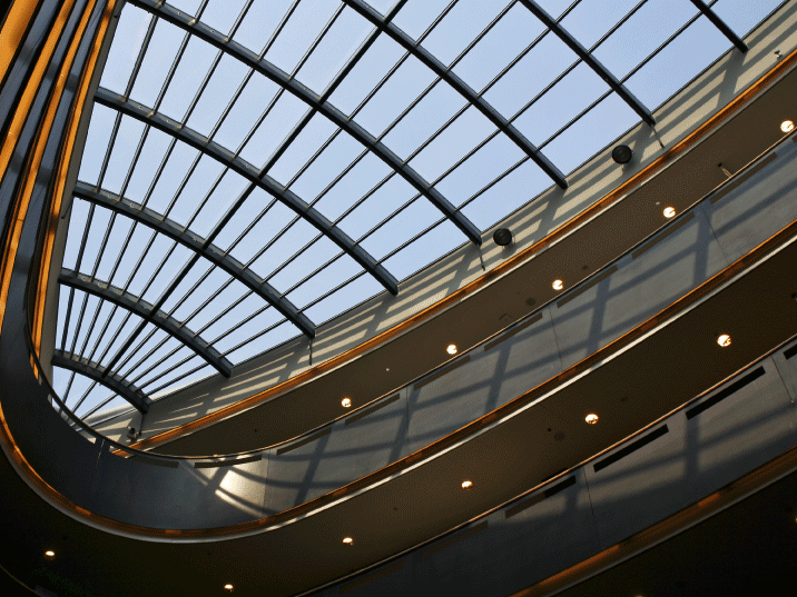 Interior of a modern building featuring a large atrium with a curved glass skylight design