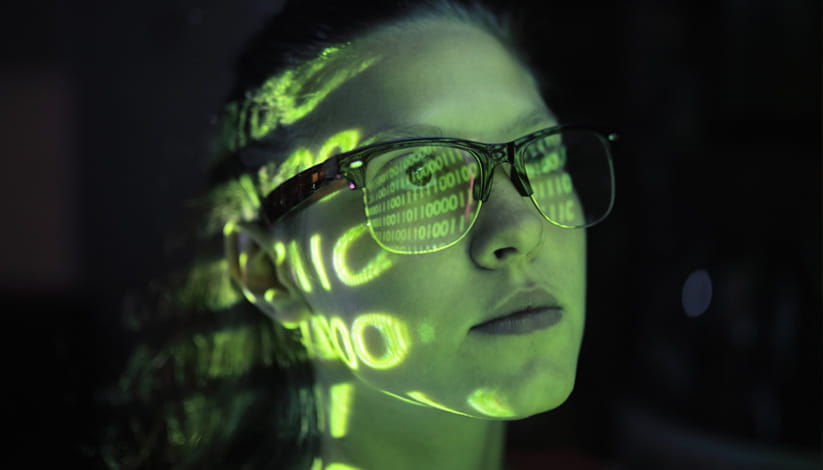 A woman wearing glasses with words projecting on her face