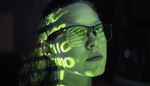 A woman wearing glasses with words projecting on her face
