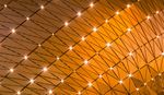 Motivo geometrico astratto di nodi luminosi collegati da linee su uno sfondo dorato.