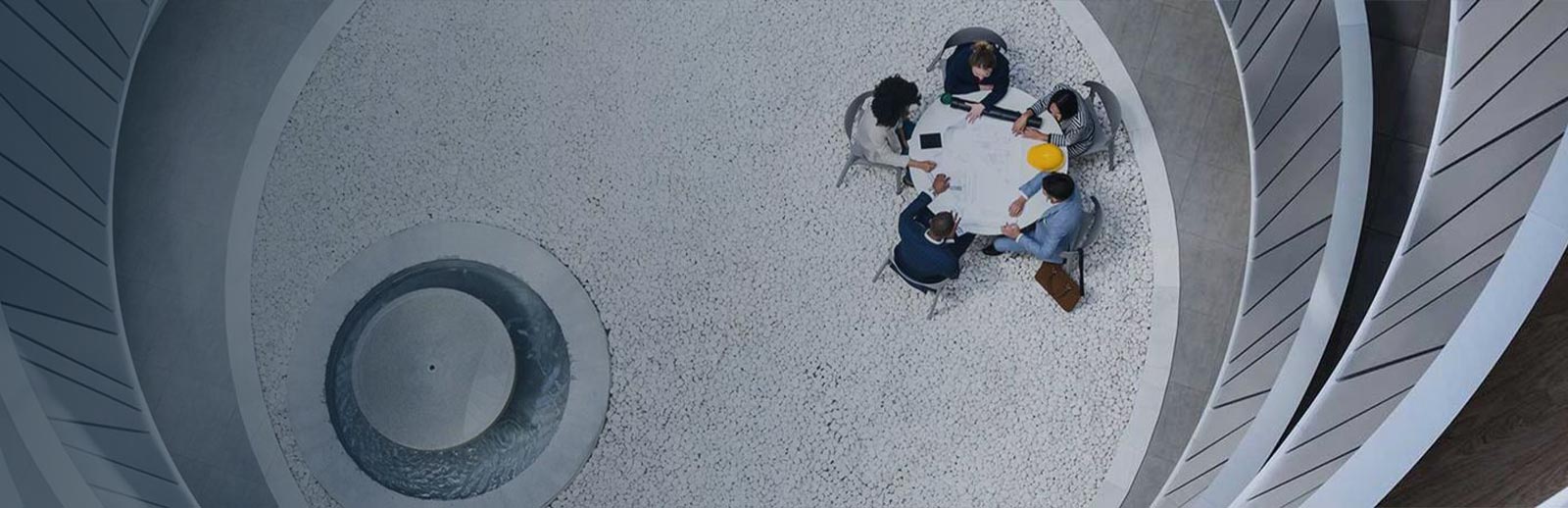 An overhead view of five people sitting around a circular table