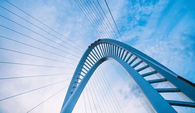 澄んだ青空の下、風景に架かる橋が穏やかで開放的な雰囲気を演出しています。